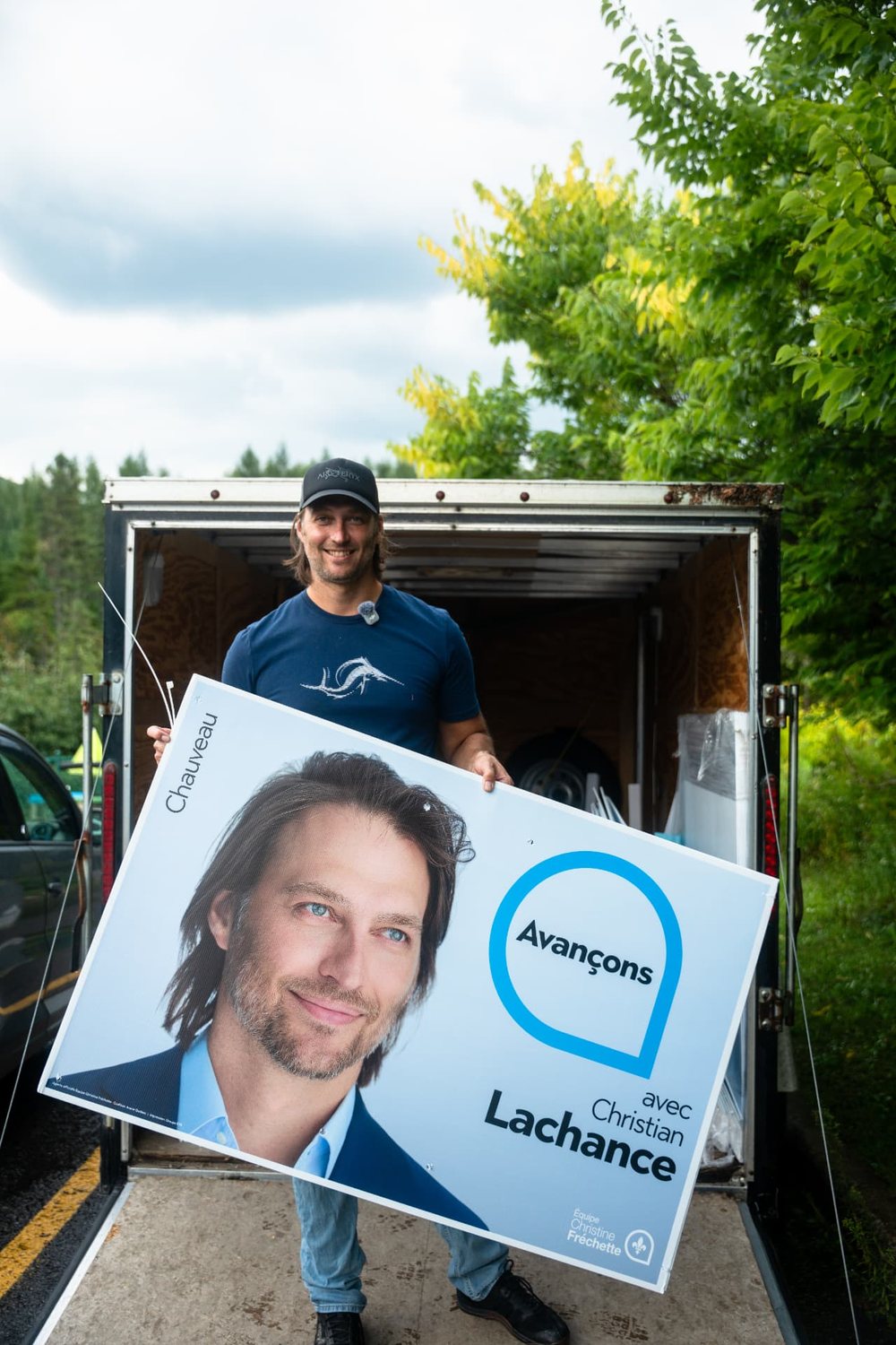 Christian Lachance installant une pancarte de campagne dans Chauveau